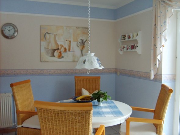 Sitzplatz innerhalb der Küche; der obere Wandteil ist mit Stuckleisten unterteilt. Dadurch lassen sich immer wieder neue Kombinationen erzielen.