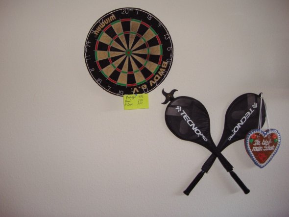 mit Steeldartscheibe und Badmintonschläger