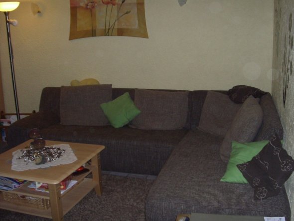 Unsere Sofaecke mit Hochflorteppich und Wandtattoo.