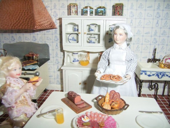 die kleine Tochter des Hauses isst bei der Köchin zu Abend - hier gibt es deftigen Leberkäs, Aufschnitt und Brezeln.