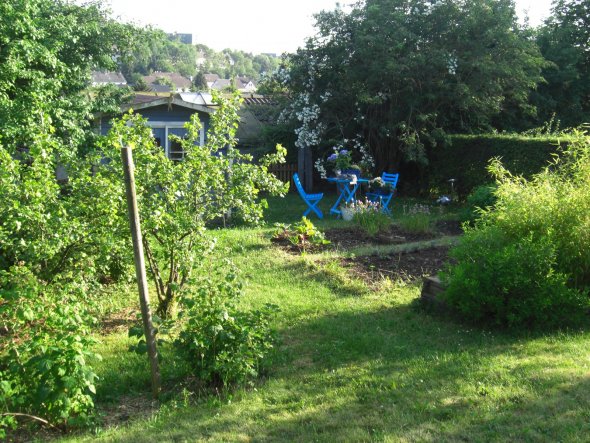 neuer Tisch im unteren Drittel, erster Versuch etwas Romantik zwischen Schuppen und Beete zu bringen