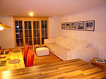 Massivholzmöbel zieren das sonst modern und weiß gehalten Wohnzimmer